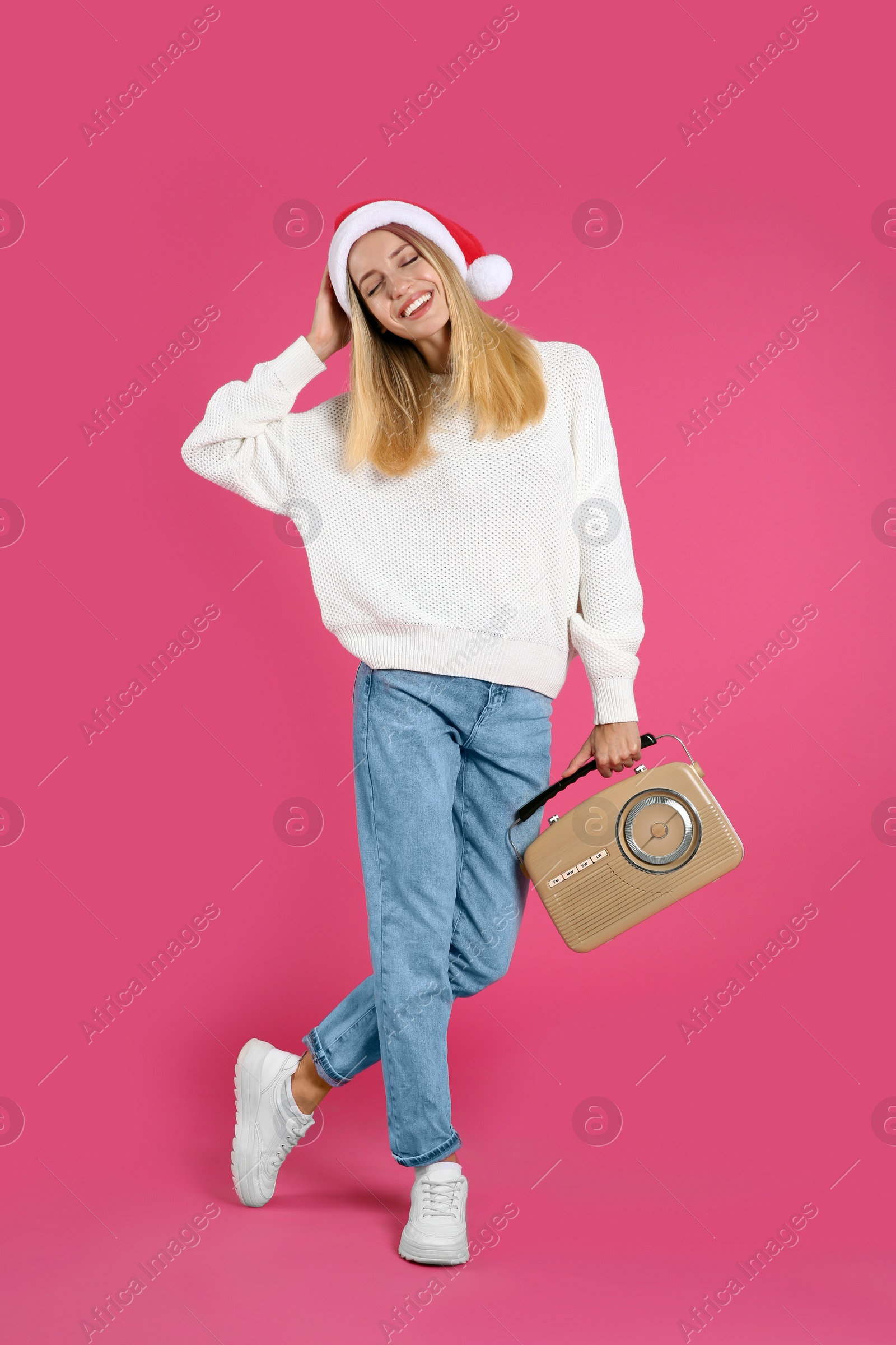 Photo of Happy woman with vintage radio on pink background. Christmas music