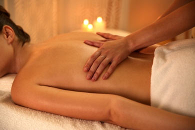 Young woman receiving back massage in spa salon, closeup