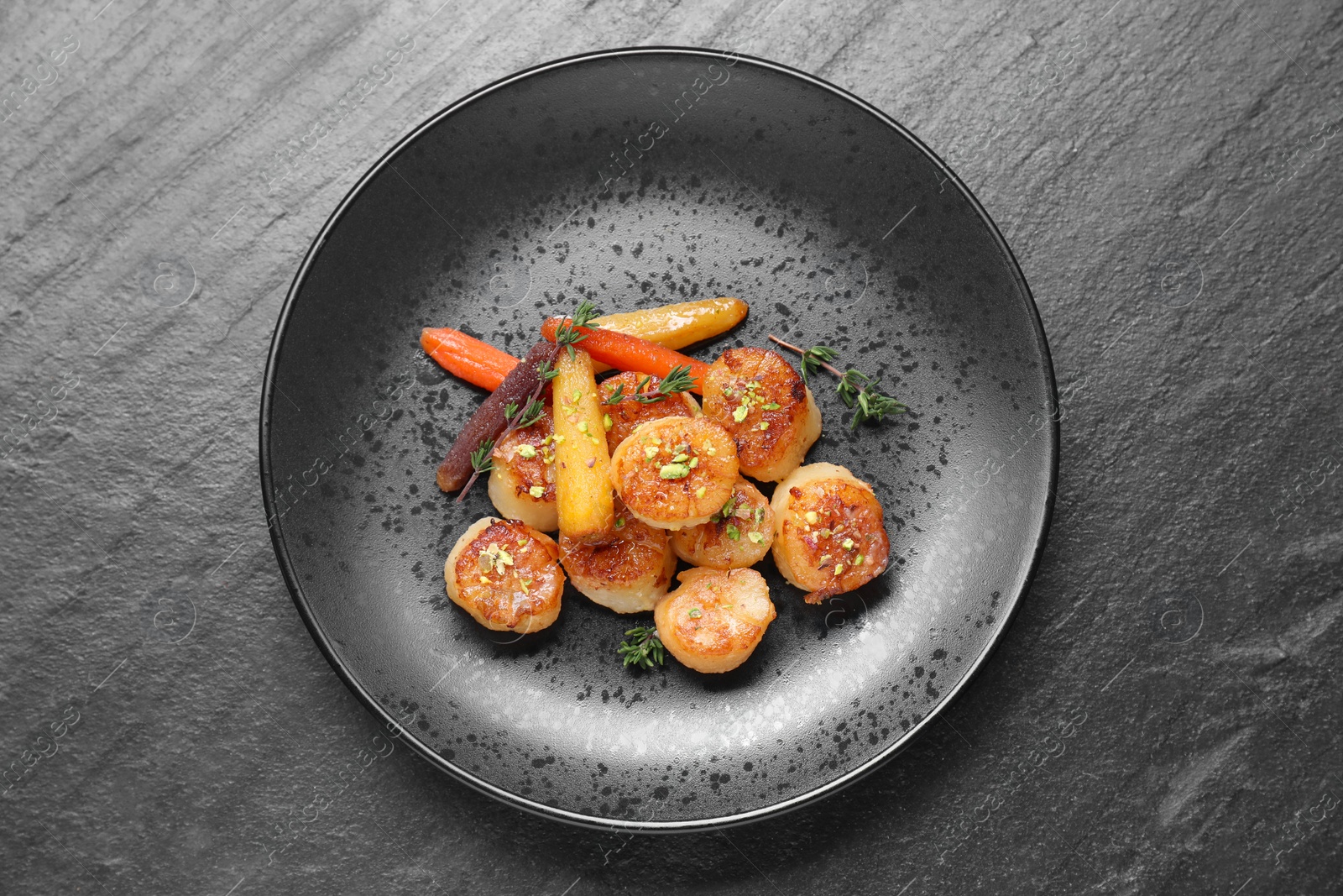 Photo of Delicious fried scallops on dark gray textured table, top view