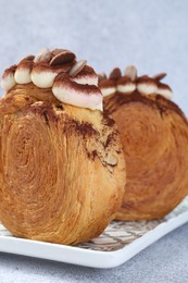 Photo of Supreme croissants with chocolate chips and cream on grey background, closeup. Tasty puff pastry