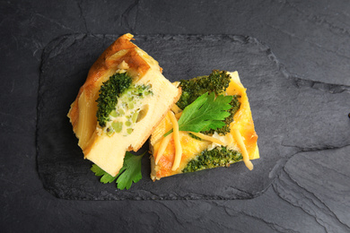 Tasty broccoli casserole served on black table, top view