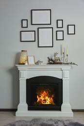 Photo of Stylish interior decorations on fireplace near white wall indoors