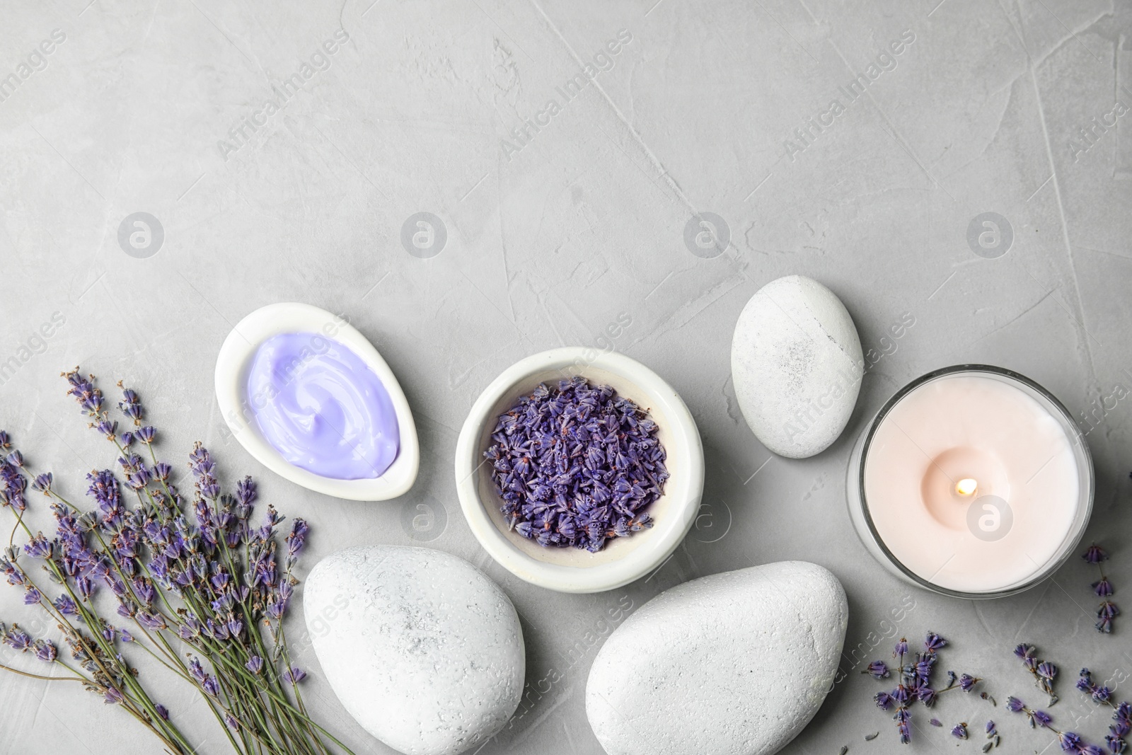 Photo of Flat lay composition with lavender flowers and natural cosmetic on grey background