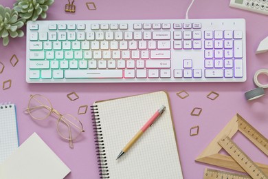 Flat lay composition with modern RGB keyboard on pink background