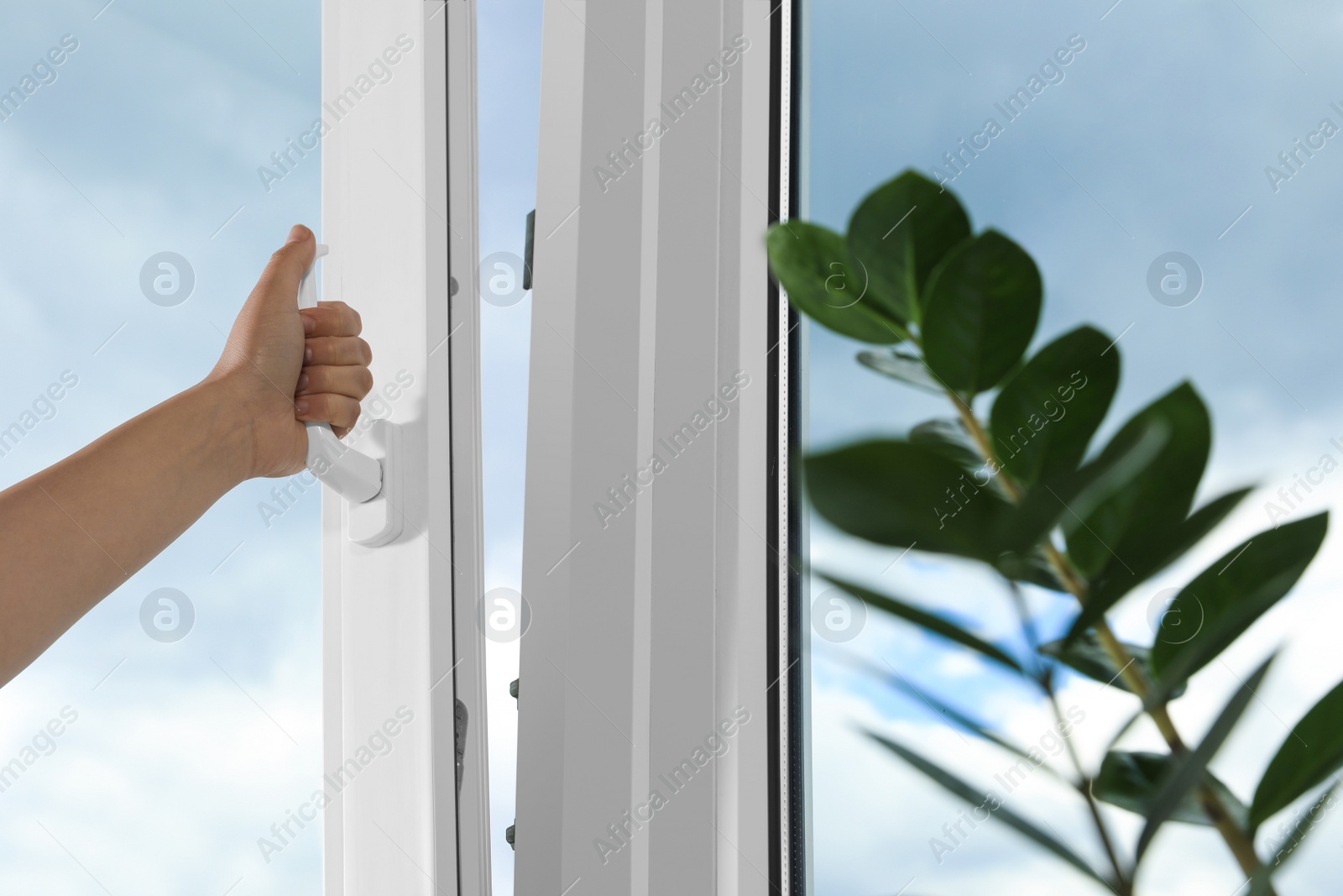 Photo of Woman opening white plastic window indoors, closeup