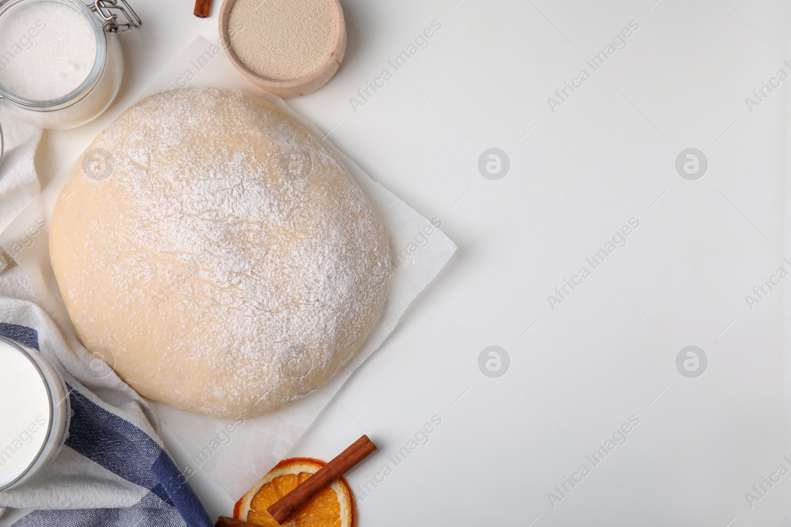 Photo of Fresh dough and ingredients on white table, flat lay. Space for text