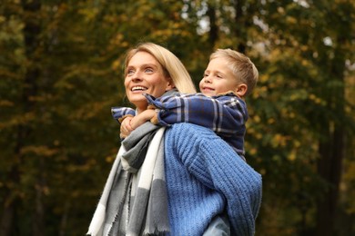 Happy mother with her son in autumn park