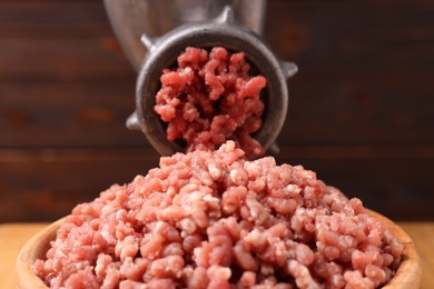 Photo of Manual meat grinder with beef mince against blurred background, closeup