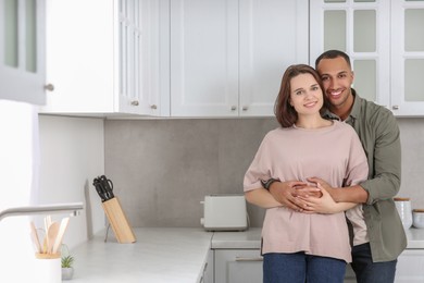 Photo of Dating agency. Lovely couple embracing in kitchen, space for text