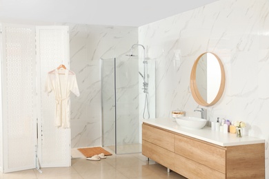 Modern bathroom interior with shower stall and folding screen