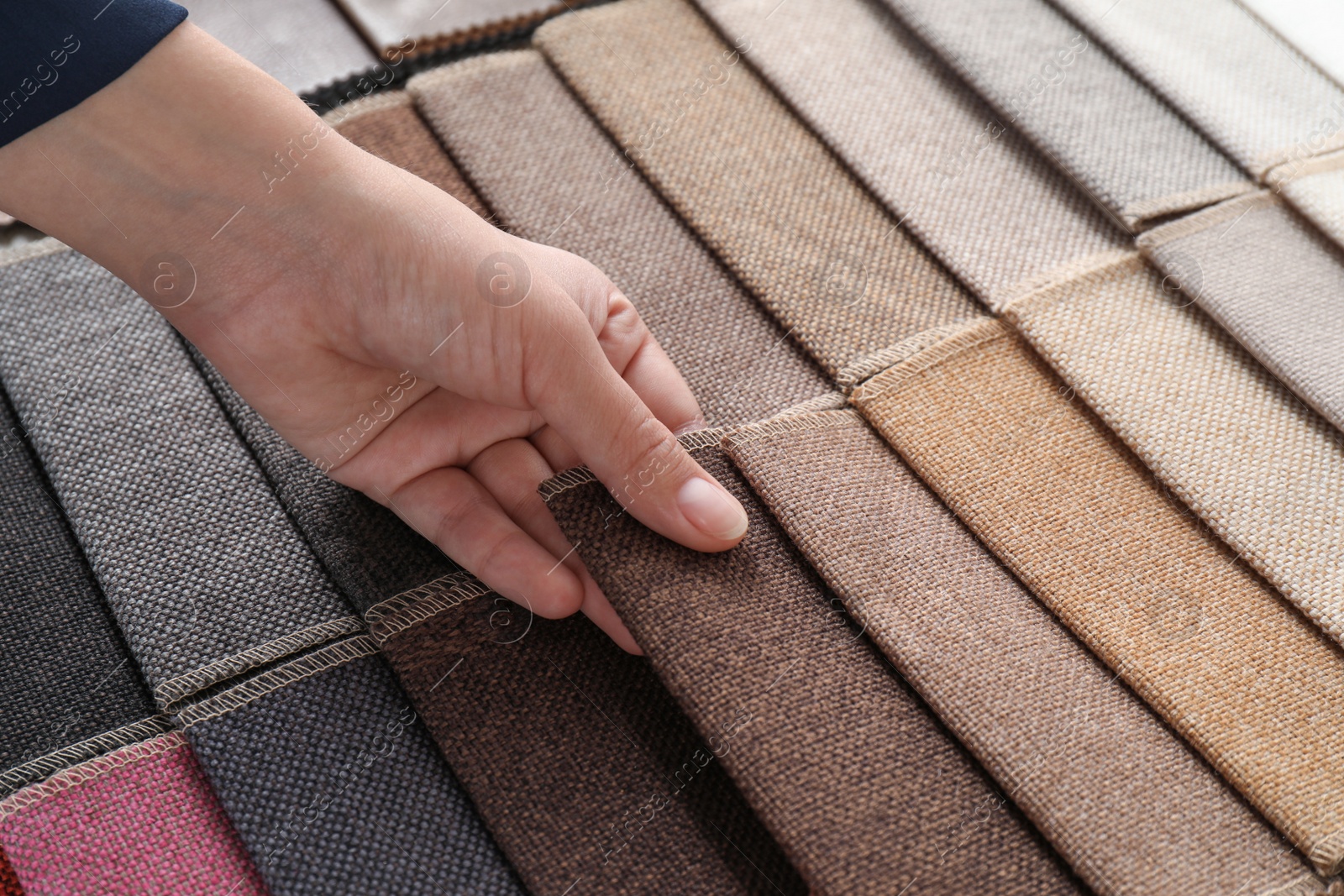 Photo of Young woman choosing among upholstery fabric samples, closeup. Interior design