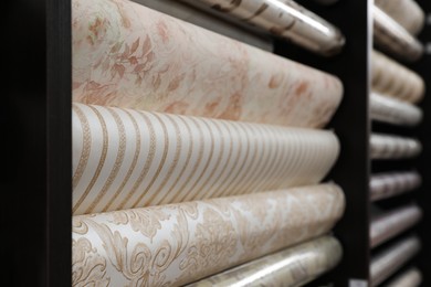 Photo of Assortment of stylish wall papers on display in shop, closeup