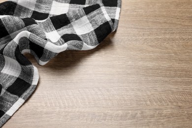 Photo of Checkered tablecloth on wooden table, above view. Space for text