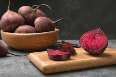 Photo of Wooden board with cut beet on table