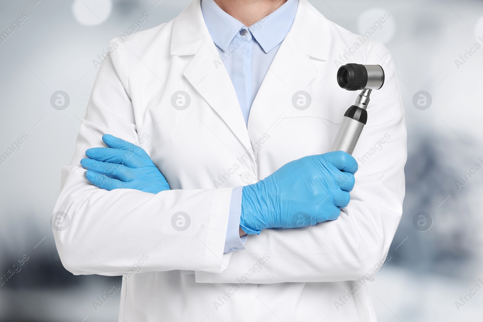 Image of Professional dermatologist with dermatoscope on blurred background, closeup