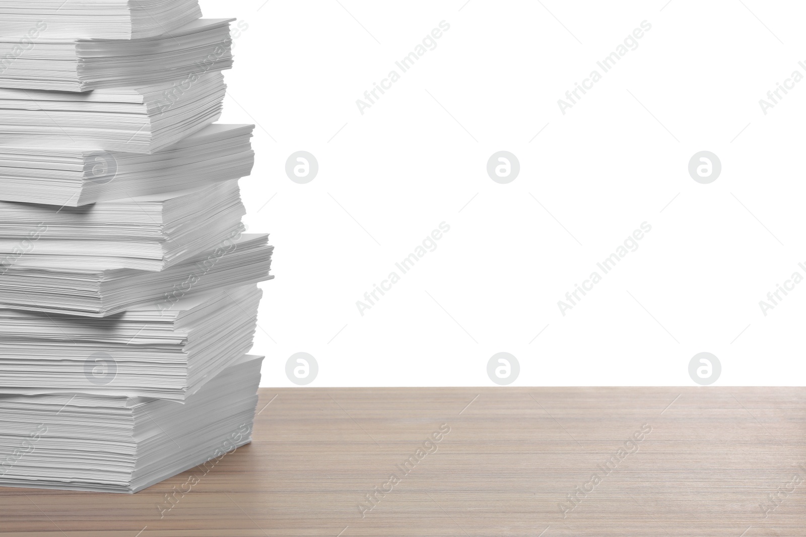 Photo of Stack of paper sheets on wooden table against white background. Space for text