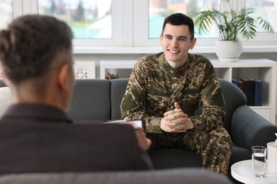 Photo of Professional psychotherapist working with military man in office