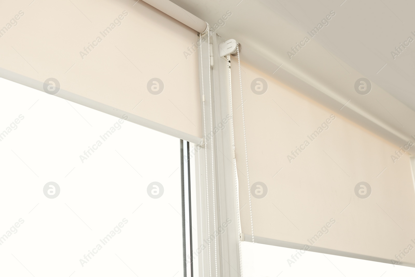 Photo of Window with modern roll blinds in room, closeup