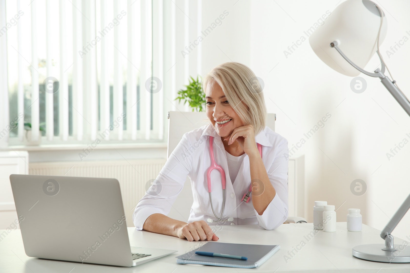 Photo of Doctor consulting patient using video chat on laptop in clinic