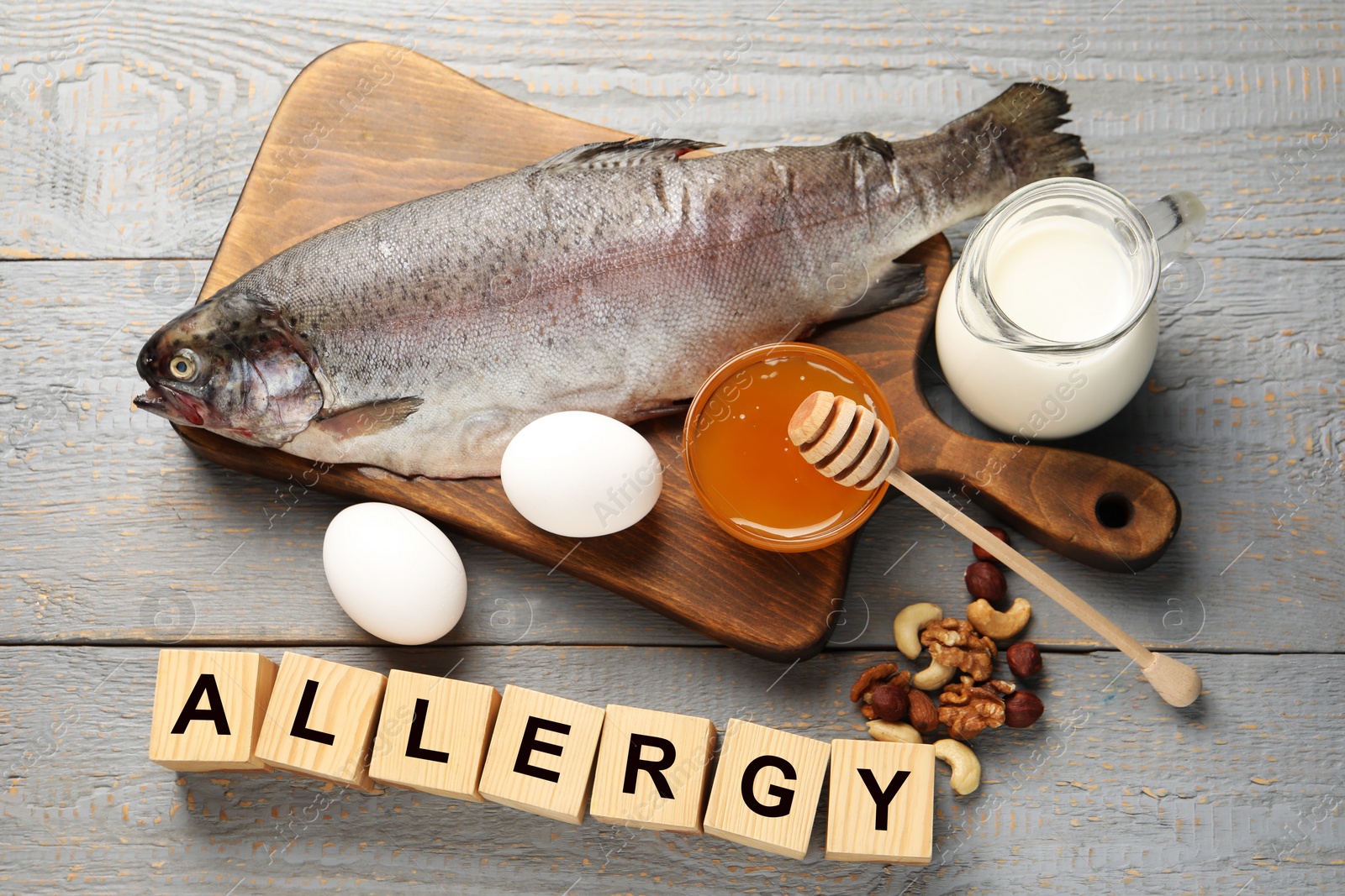 Image of Food allergy. Different fresh products and cubes on grey wooden table, flat lay