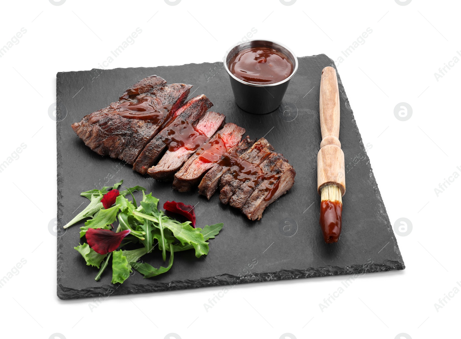 Photo of Pieces of delicious roasted beef meat with sauce and greens isolated on white