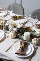 Beautiful autumn table setting. Plates, cutlery, glasses, pumpkins and floral decor