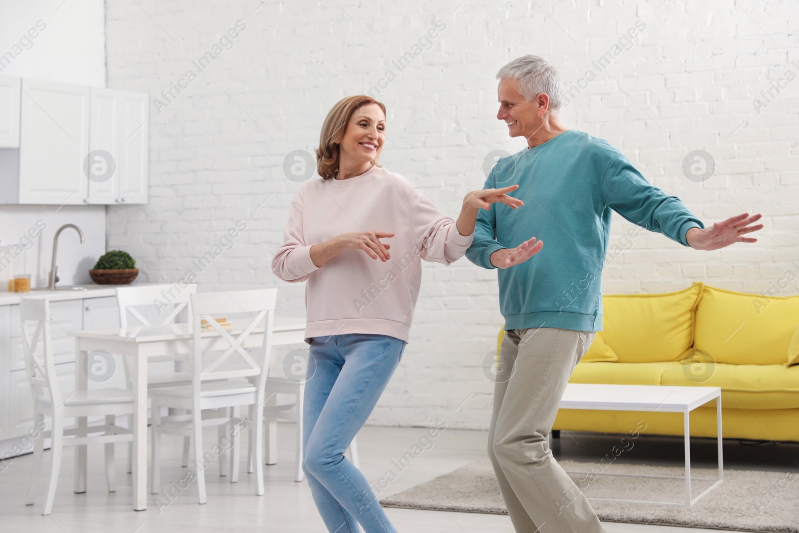 Photo of Happy senior couple dancing together in kitchen