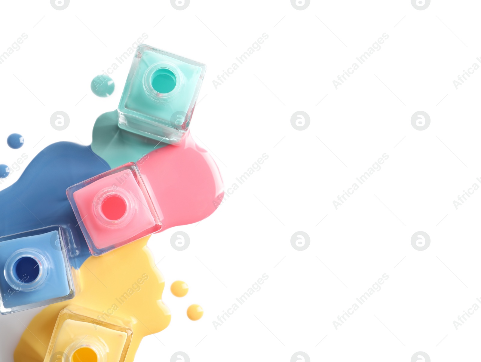 Photo of Spilled different nail polishes with bottles on white background, top view