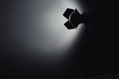 Photo of Professional photo studio lighting equipment on dark background. Space for text