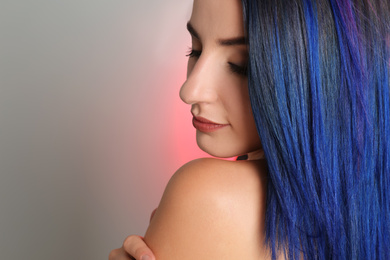 Photo of Young woman with bright dyed hair on color background, closeup. Space for text