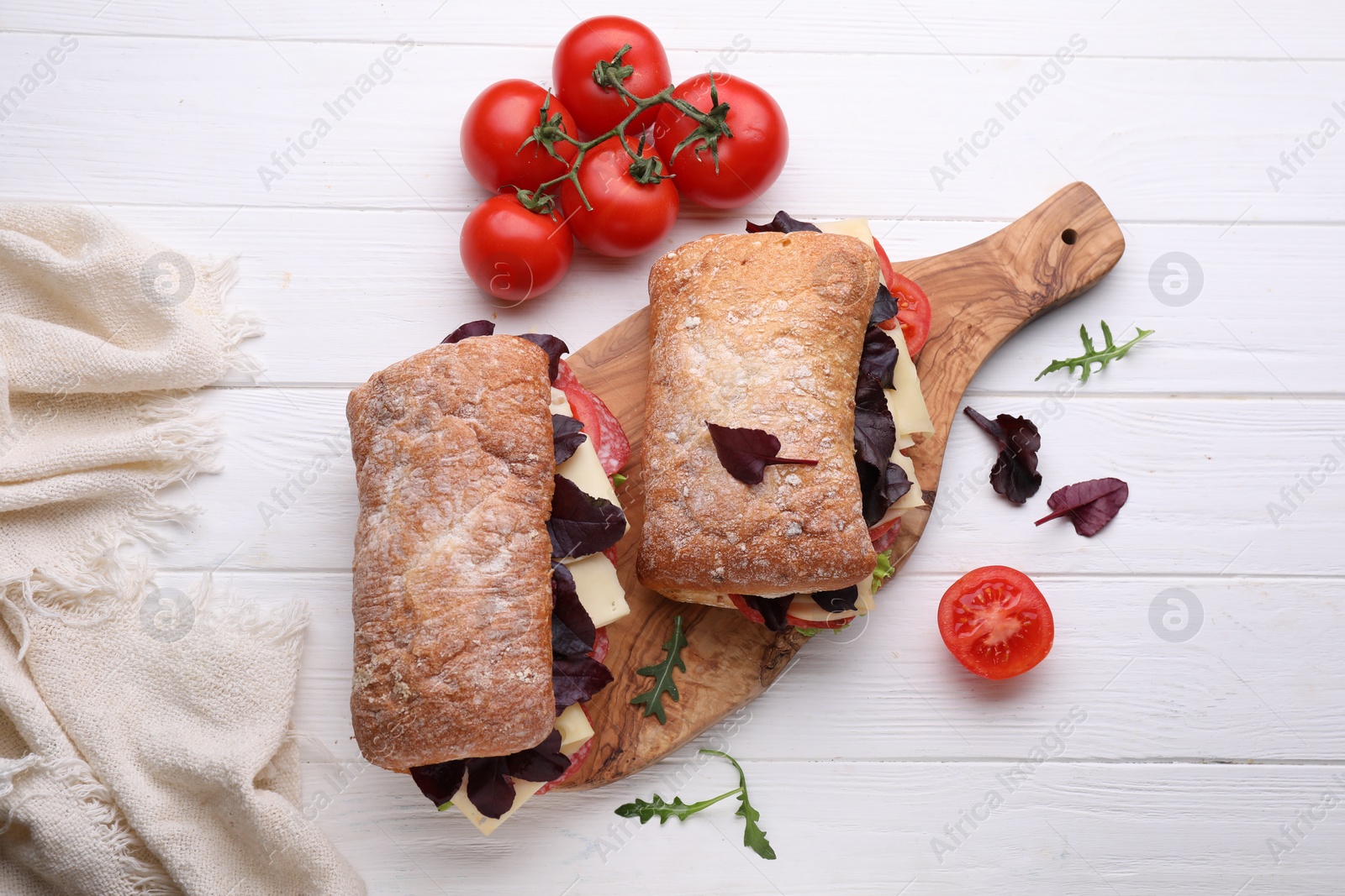 Photo of Delicious sandwiches with cheese, salami, tomato on white wooden table, flat lay