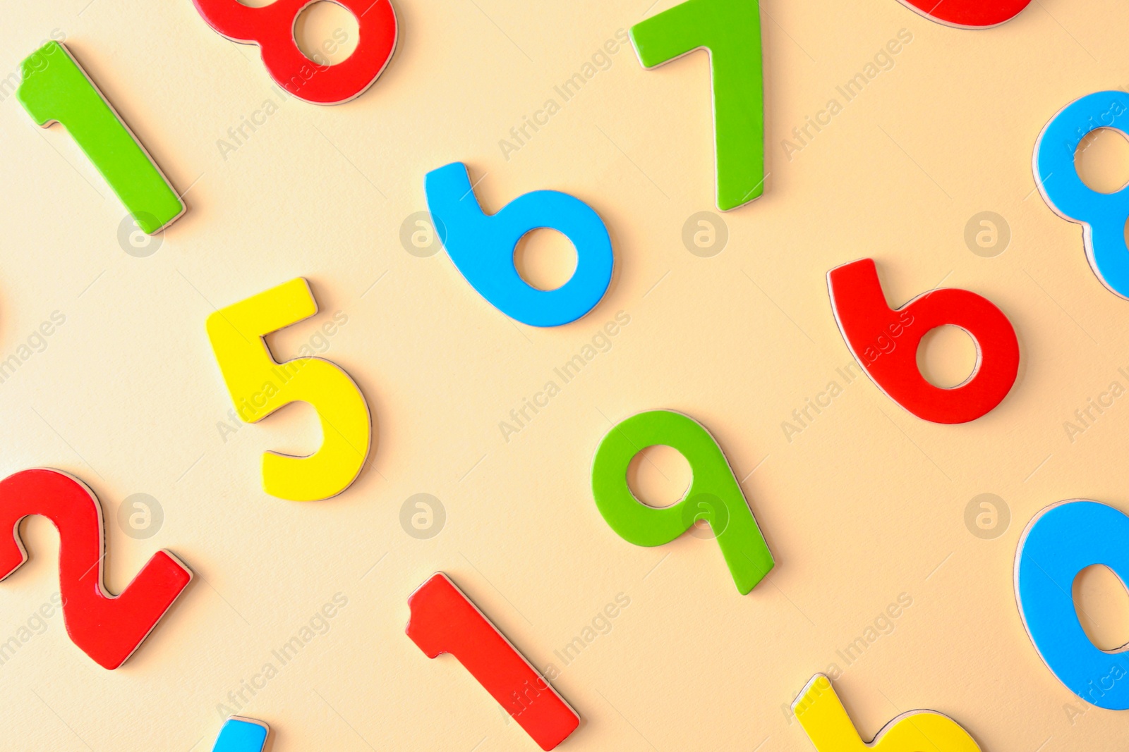 Photo of Colorful numbers on beige background, flat lay