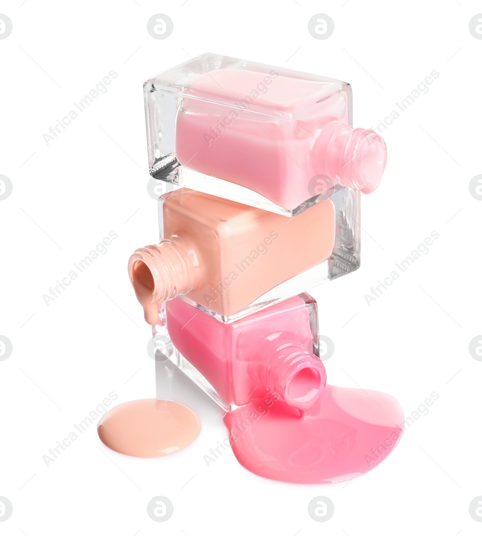 Photo of Spilled different nail polishes with bottles on white background
