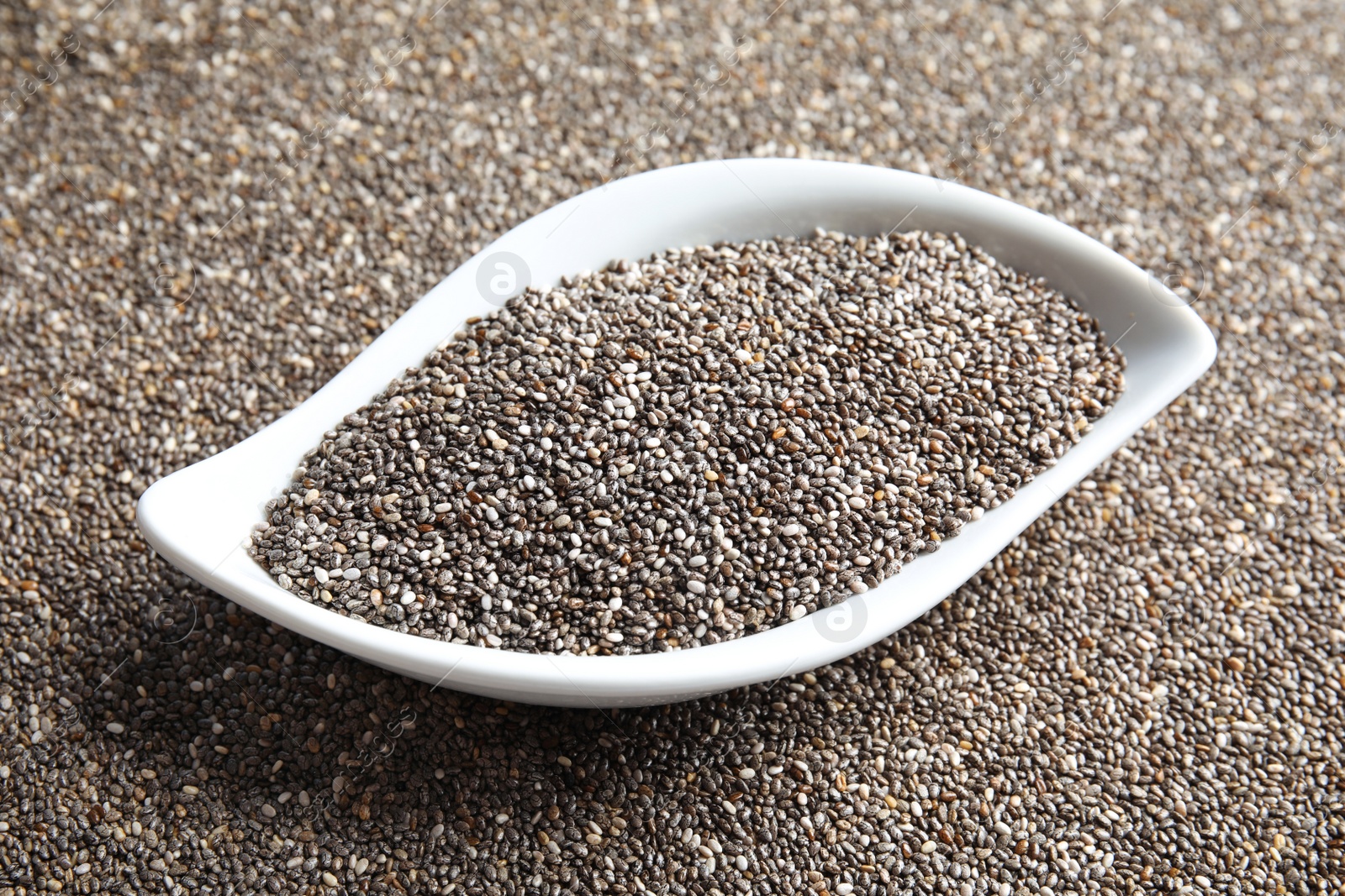 Photo of Bowl of chia seeds on grains, closeup