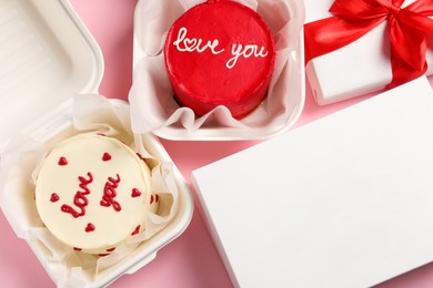 Photo of Tasty bento cakes in takeaway packagings and gift box on pink table, flat lay