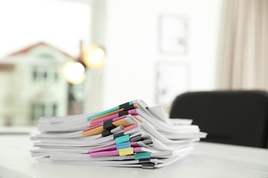 Photo of Stack of documents with paper clips on office table. Space for text