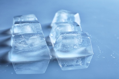 Photo of Transparent ice cubes on color mirror surface