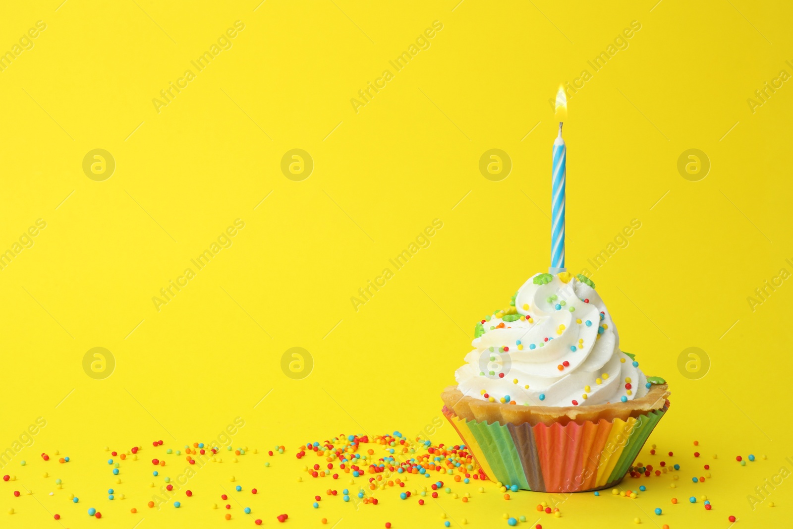 Photo of Birthday cupcake with candle on yellow background, space for text. Greeting card