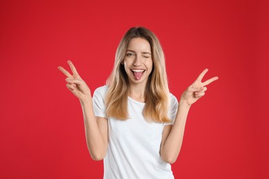 Woman showing number four with her hands on red background