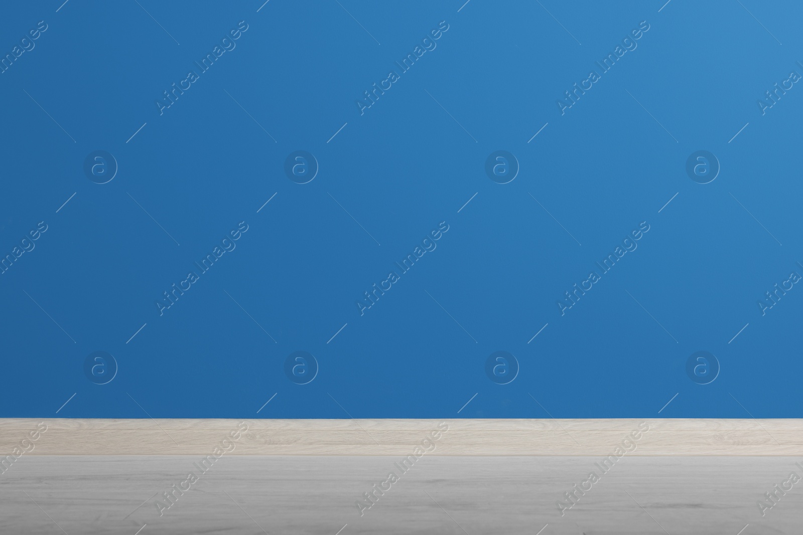 Photo of Beautiful blue wall and wooden floor in clean empty room