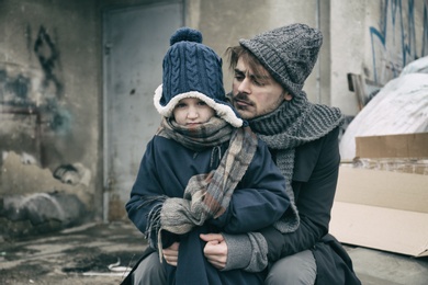 Photo of Poor father and child near garbage at dump