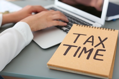 Young female calculating taxes at table, closeup