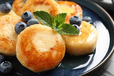 Delicious cottage cheese pancakes with blueberries on plate, closeup