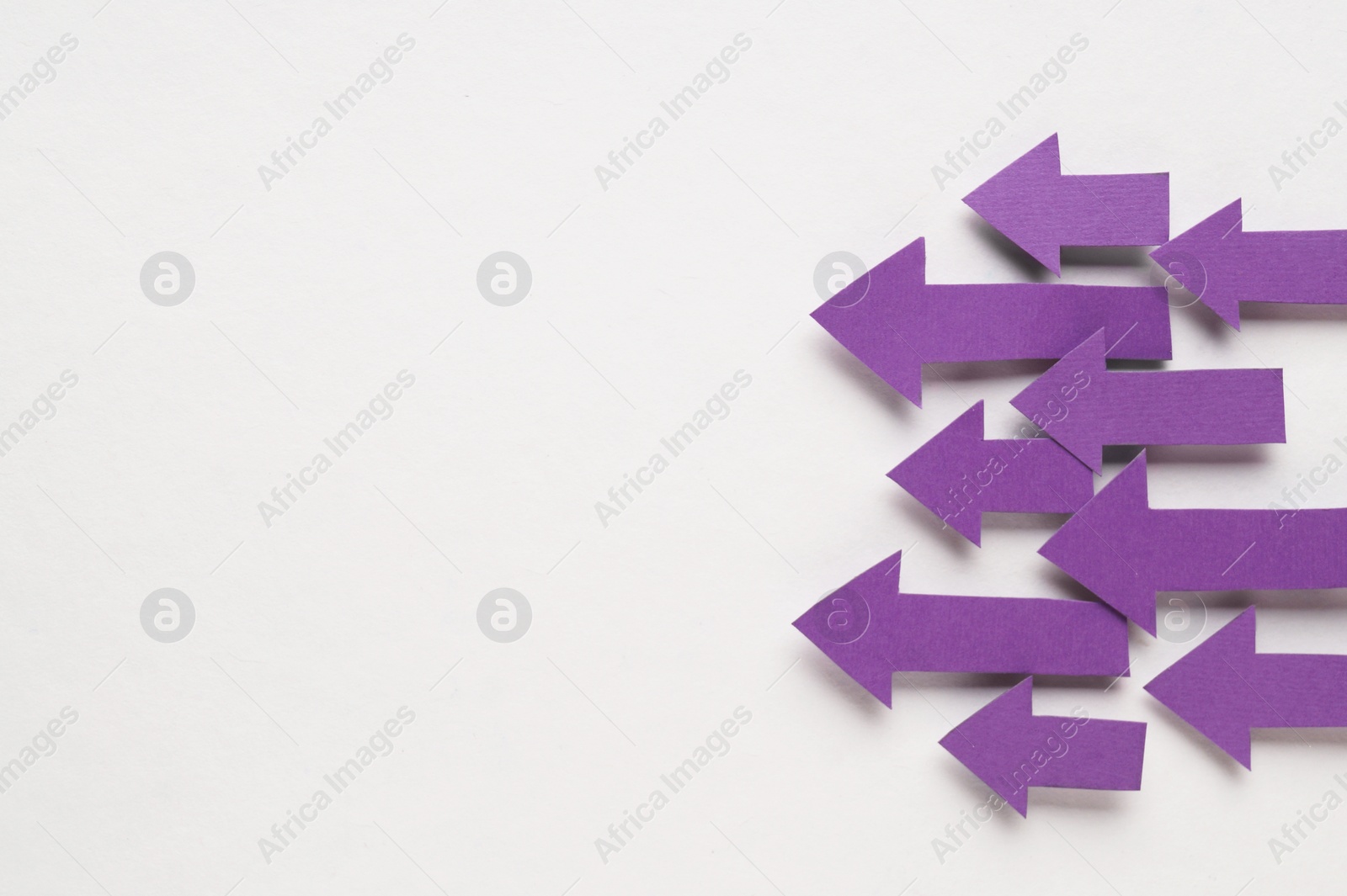 Photo of Paper arrows on white background, flat lay. Space for text