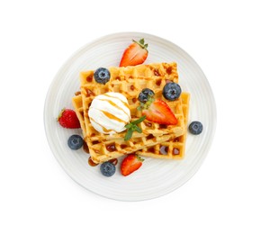 Tasty Belgian waffles with ice cream, berries and caramel syrup on white background, top view