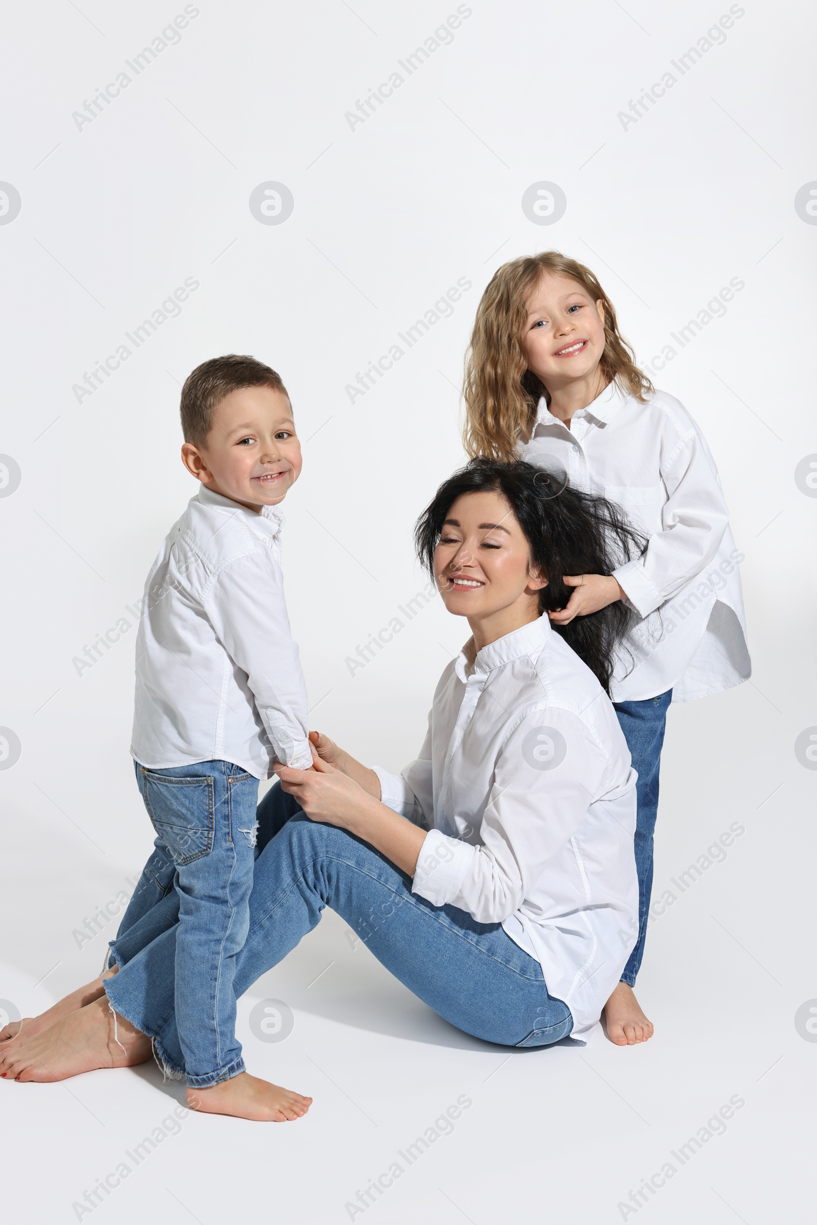 Photo of Little children with their mother on white background