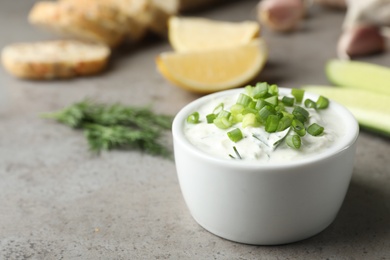 Photo of Cucumber sauce in ceramic bowl on table, space for text. Traditional Tzatziki