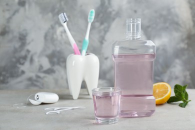Photo of Mouthwash and other oral hygiene products on grey table, space for text