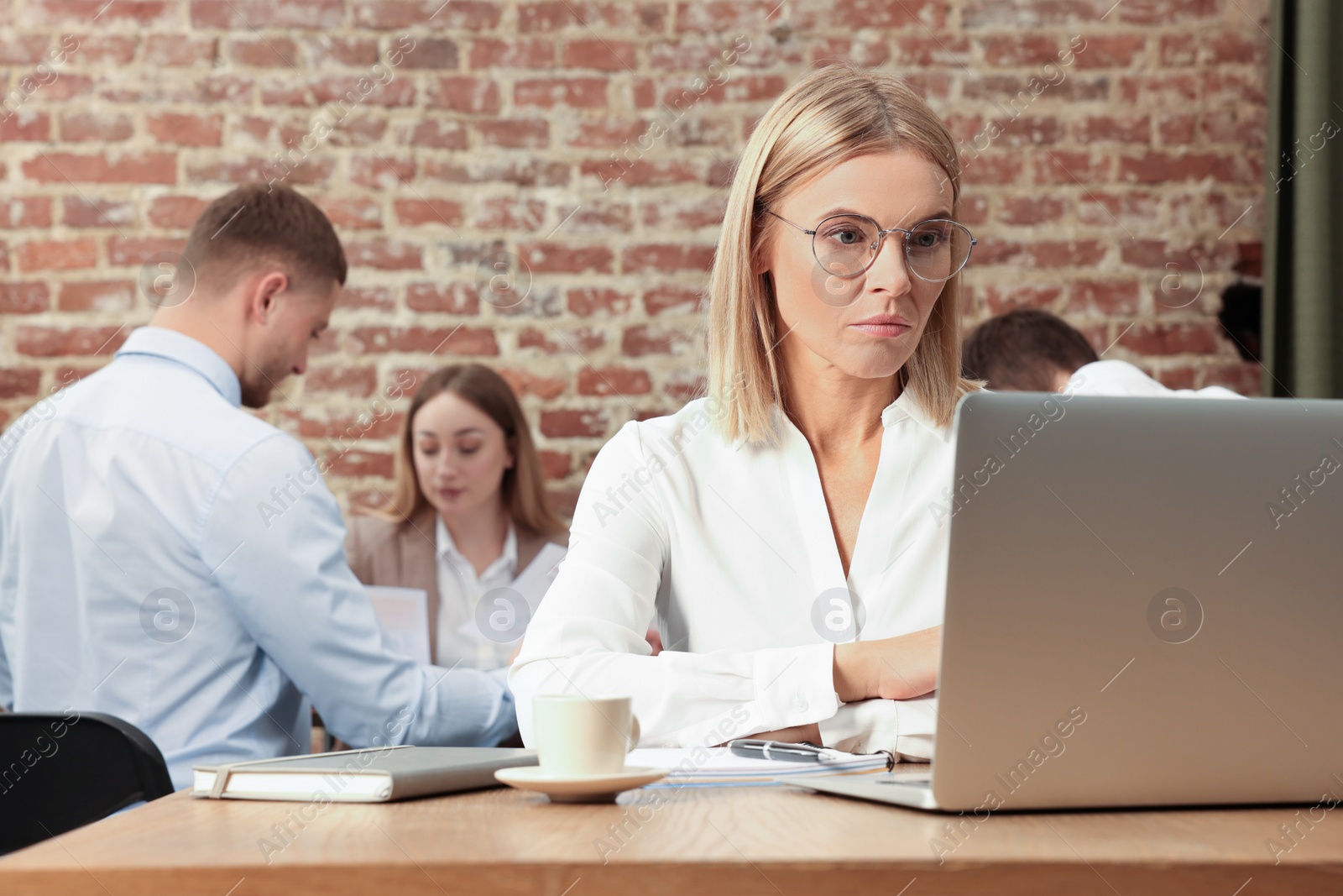 Photo of Businesswoman and her employees in office. Lady boss