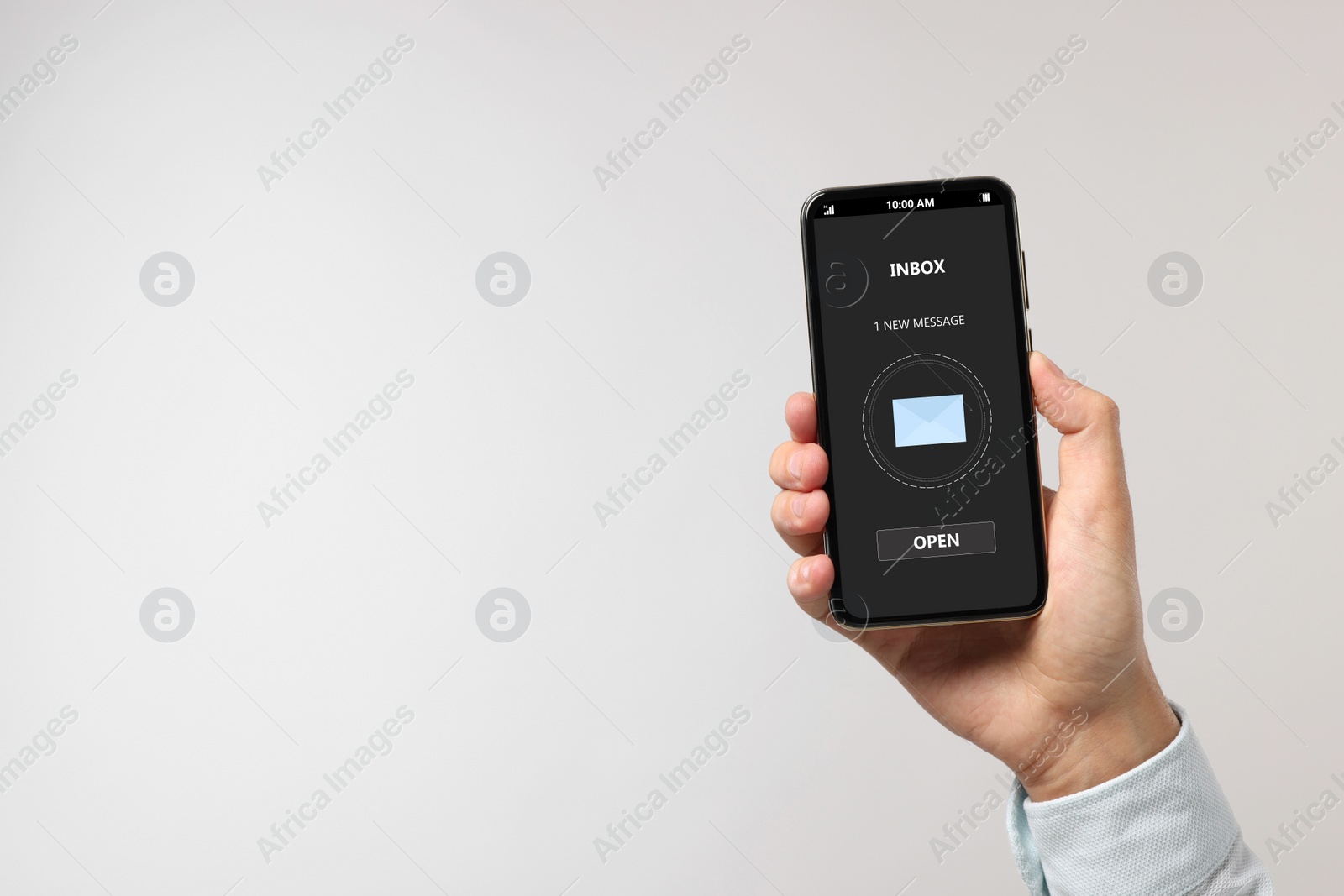 Image of Got new message. Man holding smartphone on light grey background, closeup. Space for text